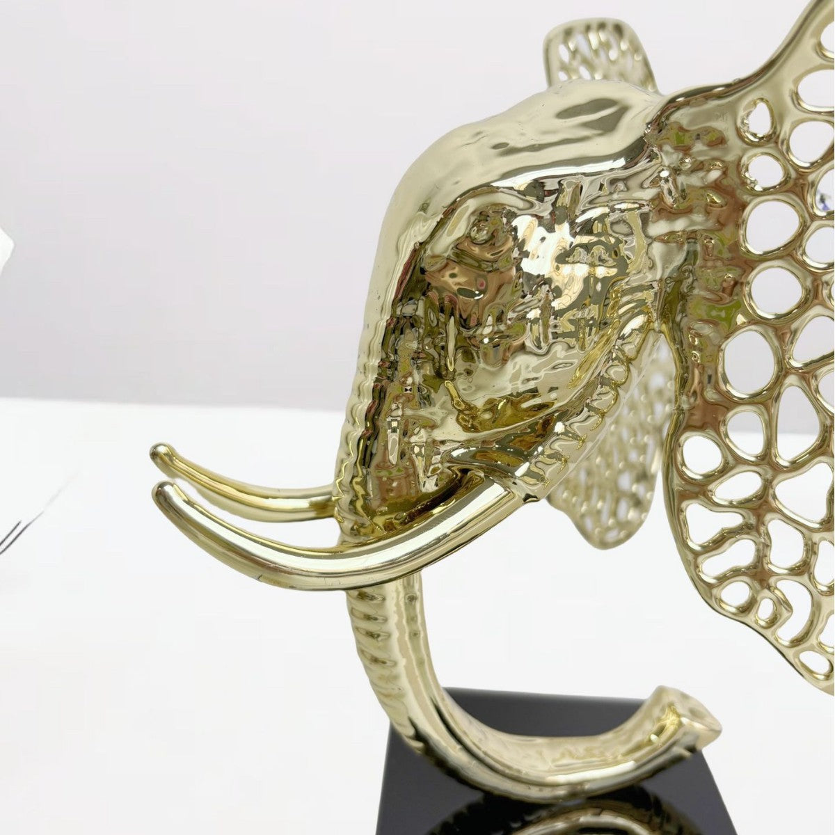 Détail sculpture éléphant doré ajouré – finition métal doré brillant, symbole de force et sérénité - vue de près