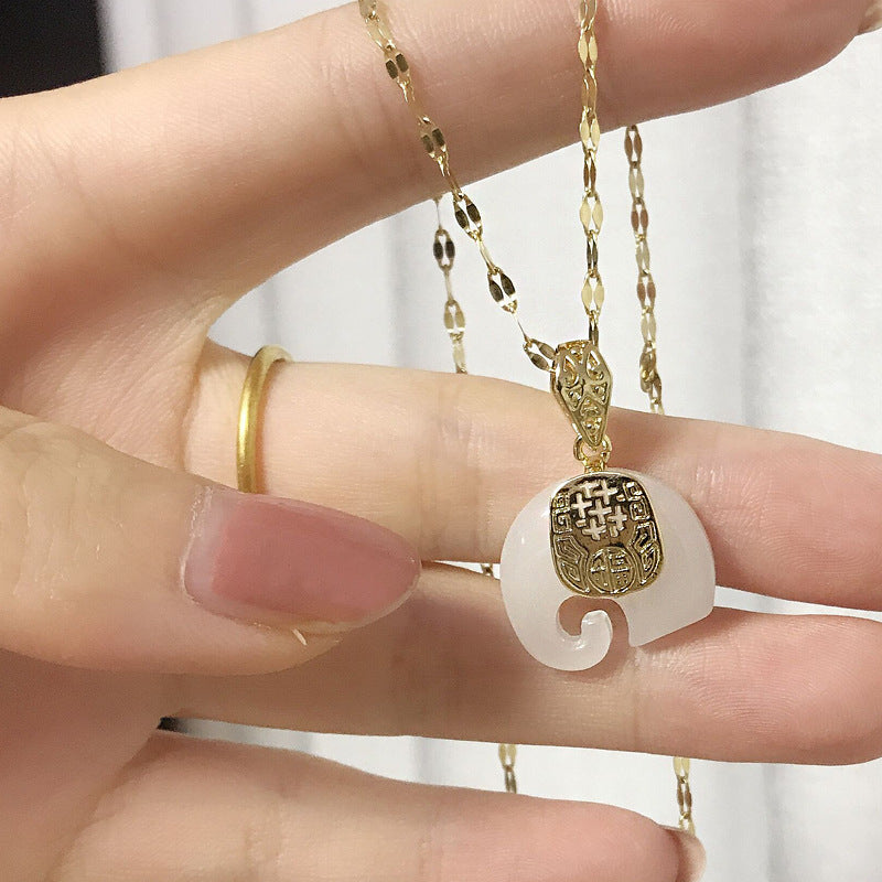 Pendentif éléphant jade tenu dans la main – collier acier titané doré, porte-bonheur symbolique