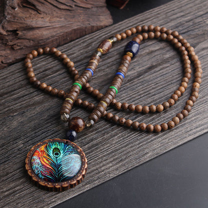 Collier sautoir ethnique bohème avec pendentif plume de paon irisé – vue d'ensemble sur fond sombre