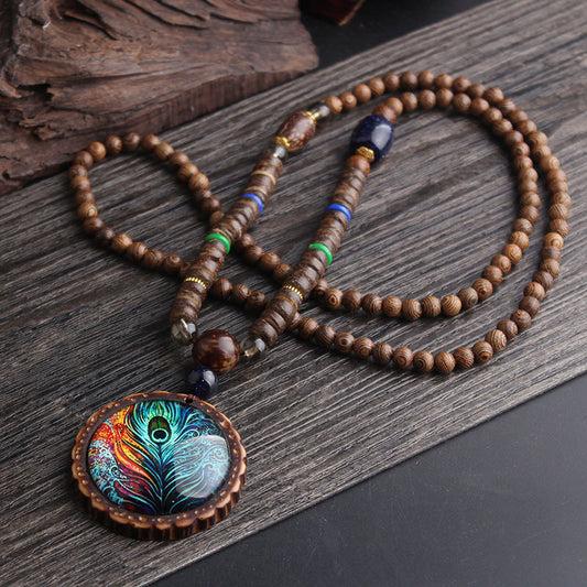 Collier sautoir ethnique bohème avec pendentif plume de paon irisé – vue d'ensemble sur fond sombre