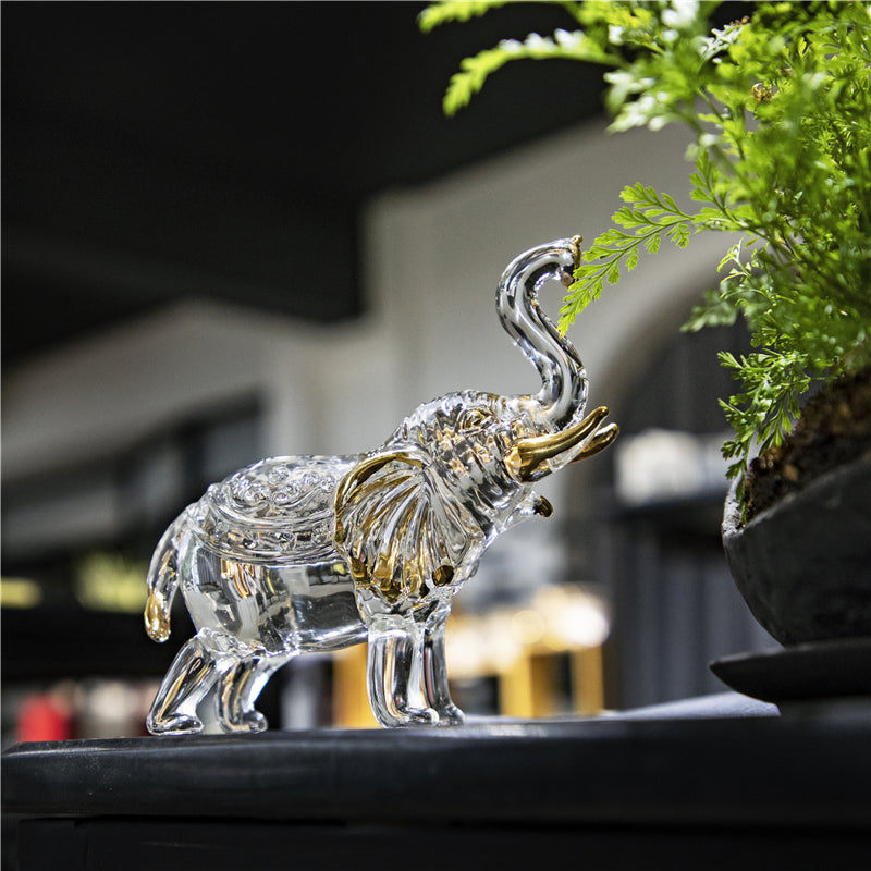Éléphant décoratif en cristal posé près d'une plante verte – décoration intérieure zen et naturelle