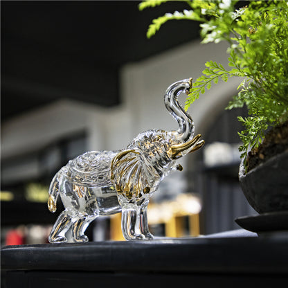 Éléphant décoratif en cristal posé près d'une plante verte – décoration intérieure zen et naturelle