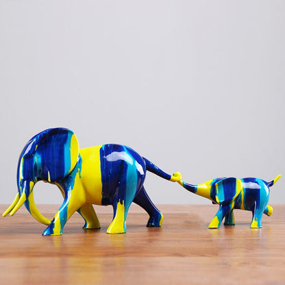Sculpture duo mère éléphant et son petit résine bleu jaune — trompe du petit tenant la queue, symbole lien maternel