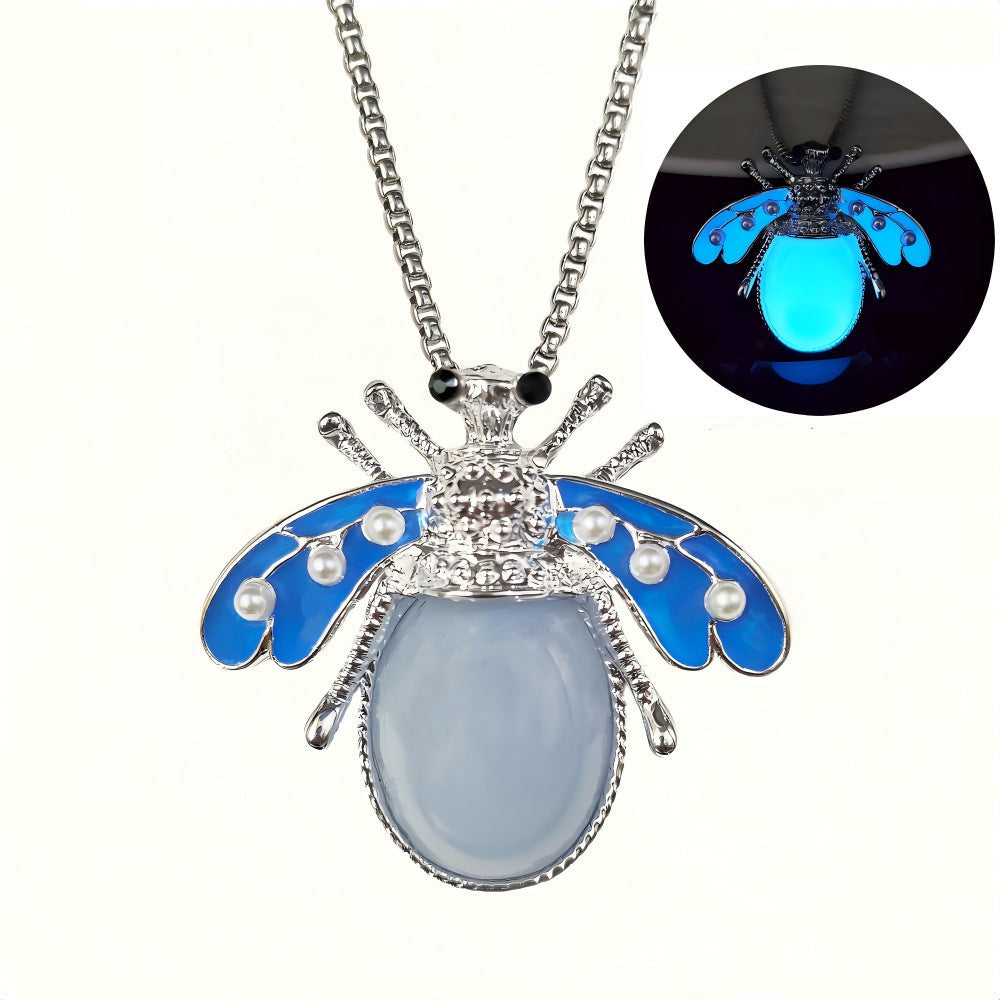 Collier pendentif luciole phosphorescent bleu — ailes émaillées bleues avec perles nacrées, lueur bleue intense dans l'obscurité