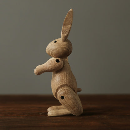 Lapin articulé en bois dans une posture curieuse, incliné vers l’avant, objet décoratif naturel.